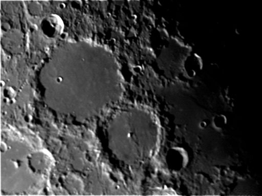 Moon Lunar surface featuring multiple craters with varying sizes and depths.