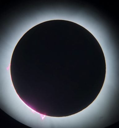 Solar Eclipse 2024 Solar eclipse with a darkened moon silhouette and bright coronal edges.
